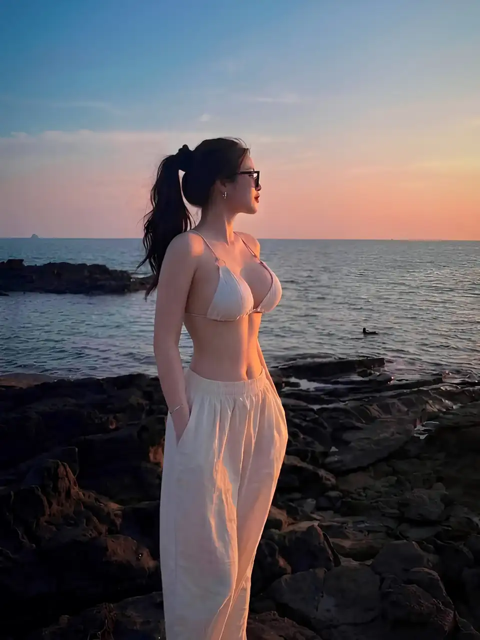 海岸落日中的泳装女性
